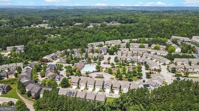 drone / aerial view featuring a wooded view and a residential view