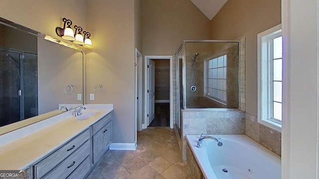 2026 Pin Oak Ter, Bonaire, GA 31005 - full bath with vanity, a shower stall, a tub with jets, vaulted ceiling, and a walk in closet