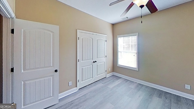 unfurnished bedroom with visible vents, baseboards, light wood-style flooring, ceiling fan, and a closet