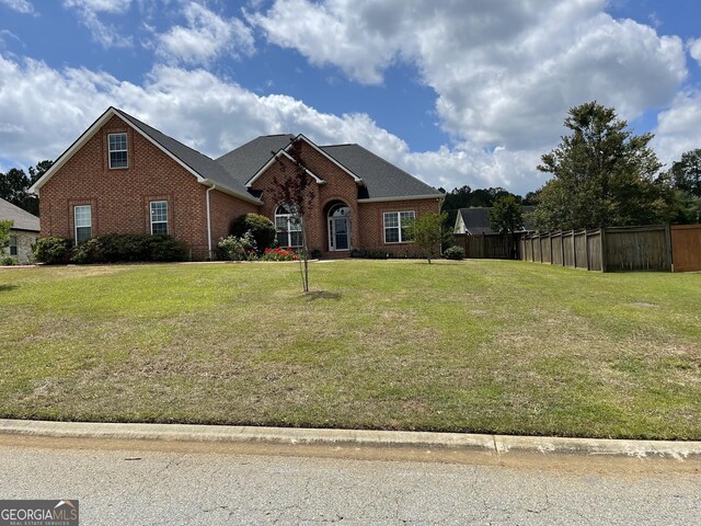 view of front of home featuring brick siding and fence