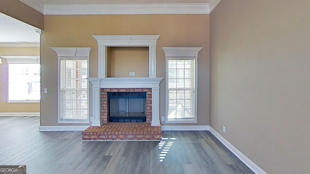 unfurnished living room featuring plenty of natural light, ornamental molding, a brick fireplace, and baseboards