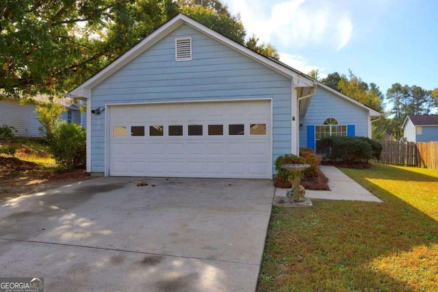 ranch-style house with driveway, an attached garage, fence, and a front yard