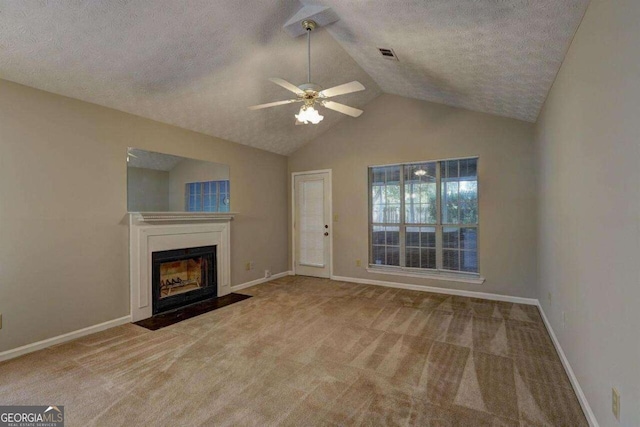 unfurnished living room with a fireplace with flush hearth, carpet flooring, vaulted ceiling, a textured ceiling, and baseboards