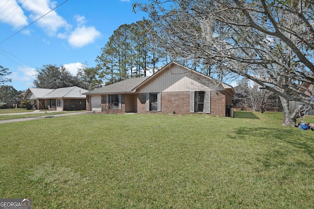 single story home featuring an attached garage, brick siding, and a front yard