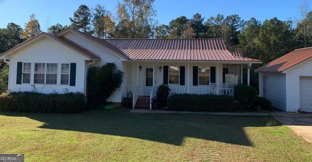 ranch-style house with a garage, metal roof, a porch, and a front lawn