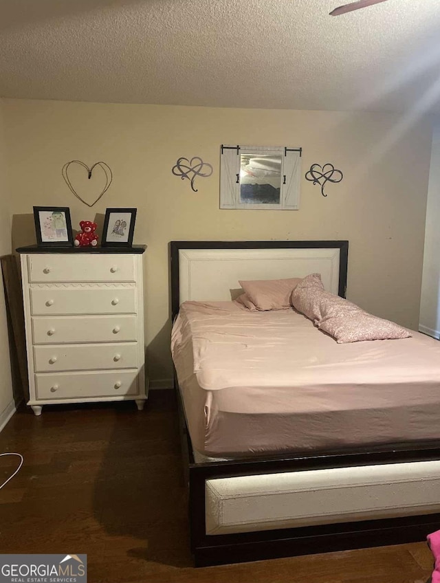 bedroom featuring dark wood-style flooring and a textured ceiling