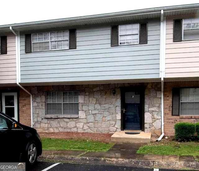 view of property featuring stone siding