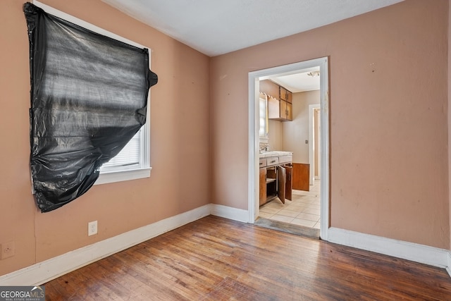 unfurnished room featuring baseboards and wood finished floors