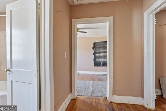 hallway with wood finished floors and baseboards