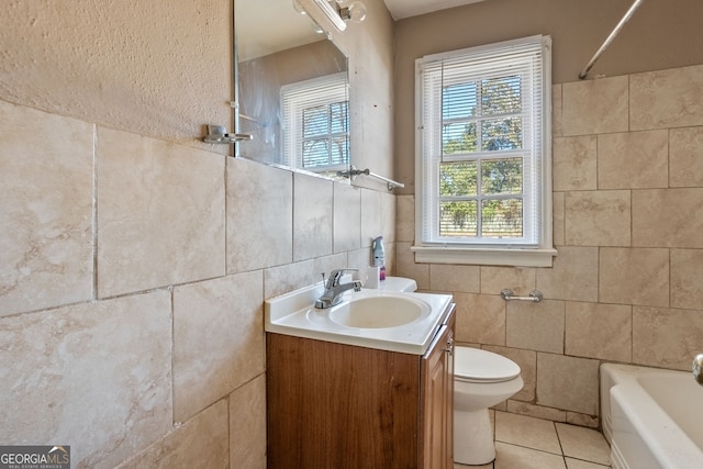 full bath featuring tile patterned floors, vanity, toilet, and tile walls