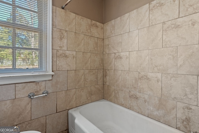 bathroom with a tub and a wealth of natural light