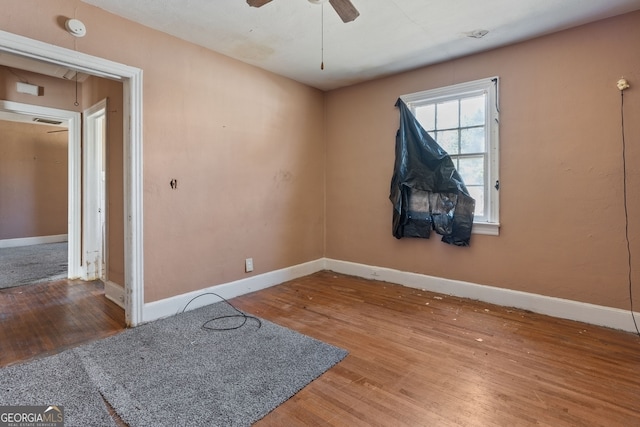 unfurnished room with a ceiling fan, baseboards, and wood finished floors