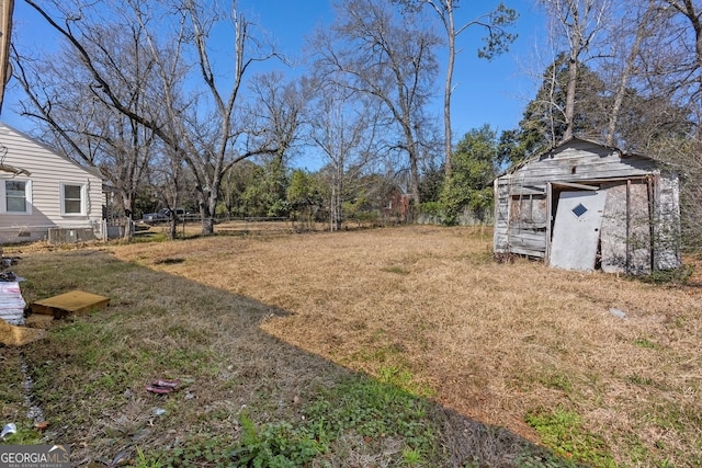 view of yard featuring an outdoor structure, fence, and a storage unit