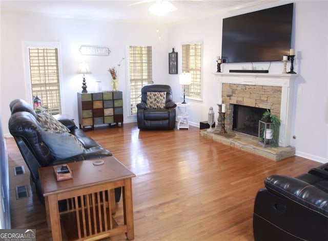 living room with a healthy amount of sunlight, a fireplace, and wood finished floors