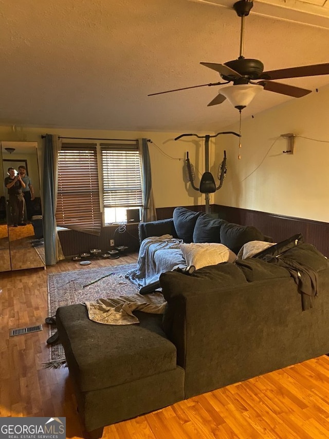 154 Buckhalter Rd, Savannah, GA 31405 - living room featuring visible vents, a ceiling fan, a wainscoted wall, wood finished floors, and a textured ceiling