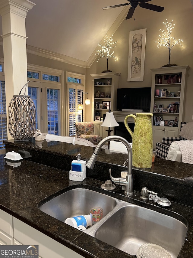 kitchen featuring a sink, a ceiling fan, open floor plan, vaulted ceiling, and crown molding