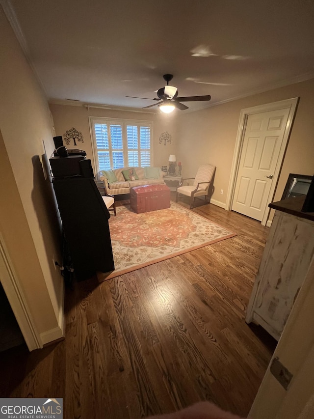 living room with baseboards, a ceiling fan, wood finished floors, and ornamental molding