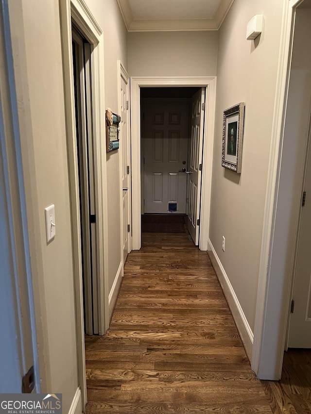 hall with baseboards, dark wood finished floors, and crown molding