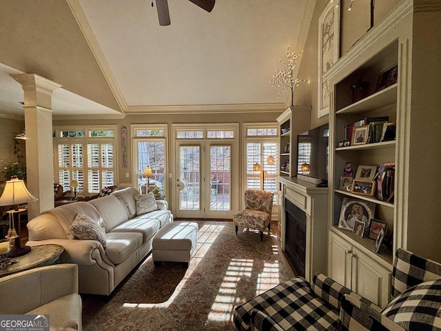 living room with plenty of natural light, decorative columns, a fireplace, and ornamental molding