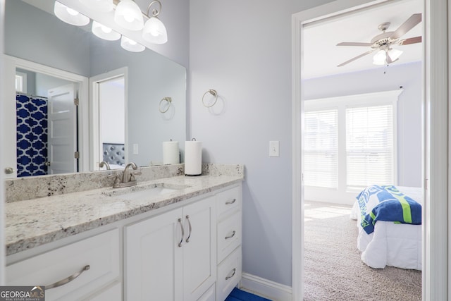 ensuite bathroom with baseboards, ensuite bath, vanity, and a ceiling fan