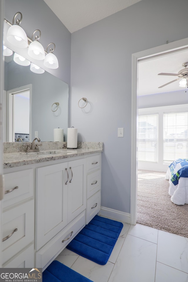 bathroom with marble finish floor, baseboards, a ceiling fan, and vanity