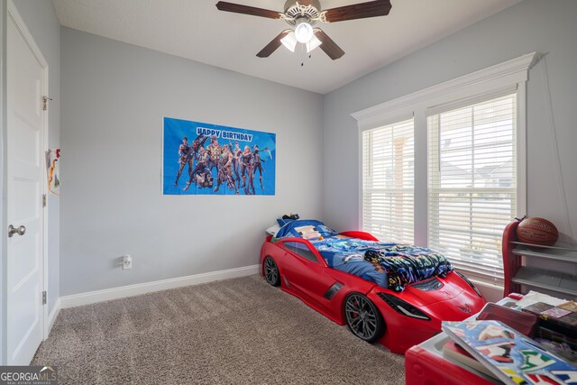 carpeted bedroom with ceiling fan, multiple windows, and baseboards