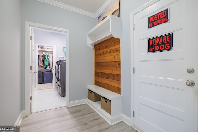 mudroom with baseboards, washing machine and clothes dryer, light wood-style flooring, and crown molding