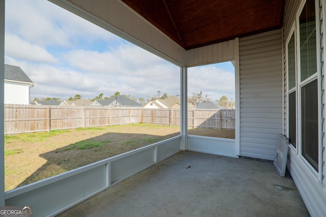 unfurnished sunroom with wood ceiling, a residential view, and vaulted ceiling