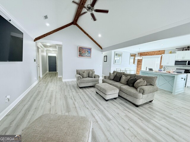 living area with beam ceiling, visible vents, high vaulted ceiling, light wood-type flooring, and baseboards