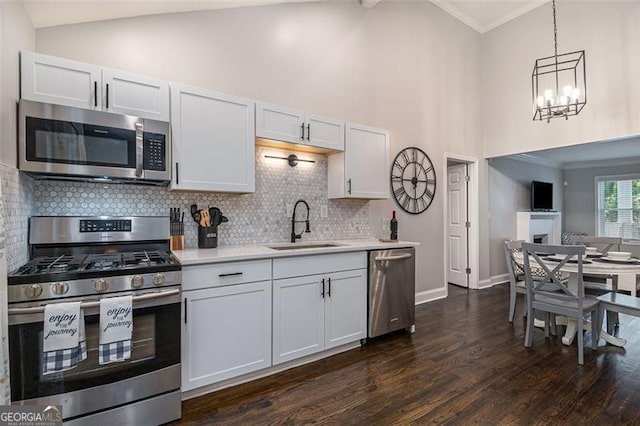 125 Warren St, Atlanta, GA 30317 - kitchen with dark wood finished floors, stainless steel appliances, light countertops, ornamental molding, and a sink