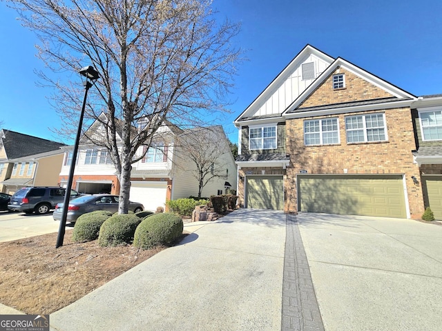 view of front facade with board and batten siding, brick siding, driveway, and an attached garage