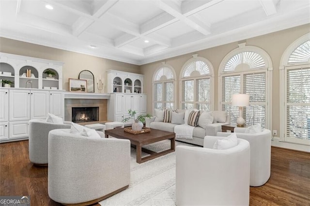 living room featuring a warm lit fireplace, beam ceiling, and wood finished floors