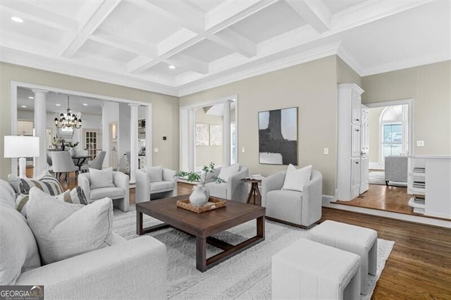 living area with beam ceiling, a notable chandelier, wood finished floors, coffered ceiling, and ornate columns