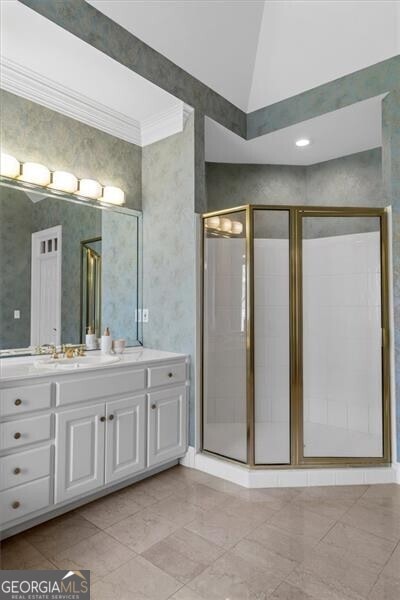 full bathroom with crown molding, a stall shower, vaulted ceiling, vanity, and wallpapered walls