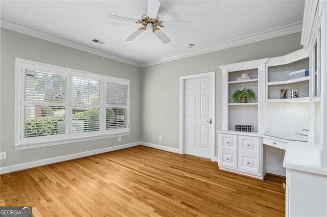 unfurnished office featuring ornamental molding, light wood-type flooring, built in study area, and visible vents