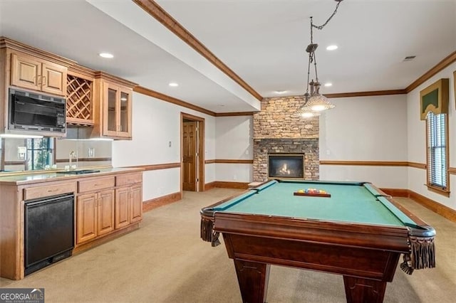 rec room featuring baseboards, a fireplace, ornamental molding, and a sink