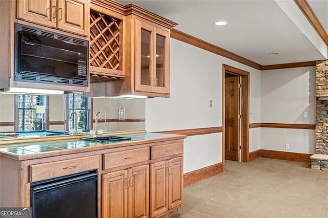 kitchen featuring crown molding, light colored carpet, glass insert cabinets, black microwave, and baseboards