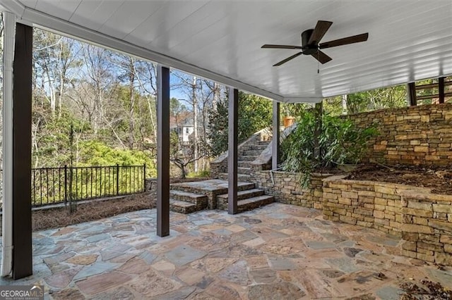 unfurnished sunroom with ceiling fan