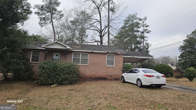 view of front of property with brick siding, crawl space, a front yard, and an attached carport