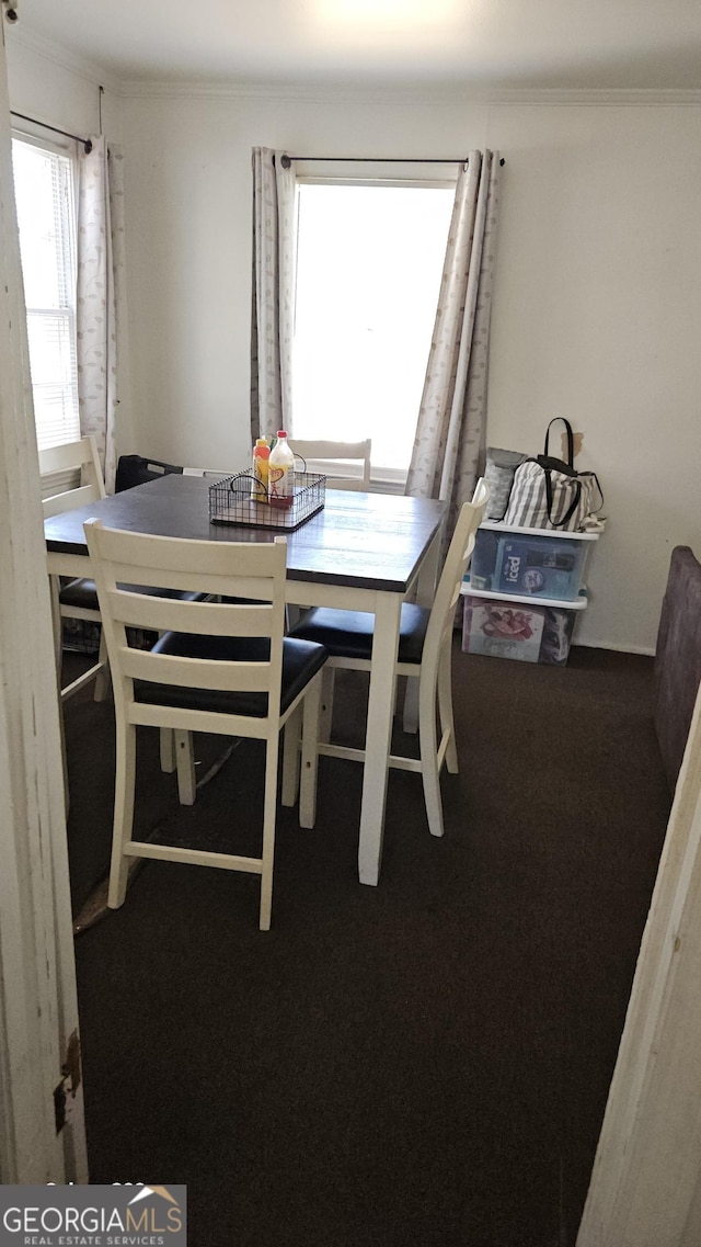 dining space with ornamental molding and carpet flooring