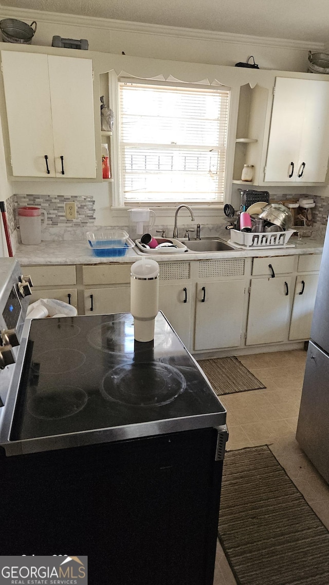 kitchen featuring electric range, open shelves, a sink, and light countertops