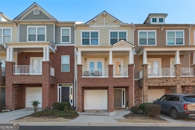 townhome / multi-family property with driveway, a garage, and brick siding