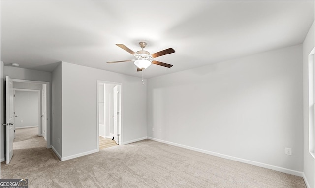 unfurnished bedroom with light carpet, a ceiling fan, and baseboards