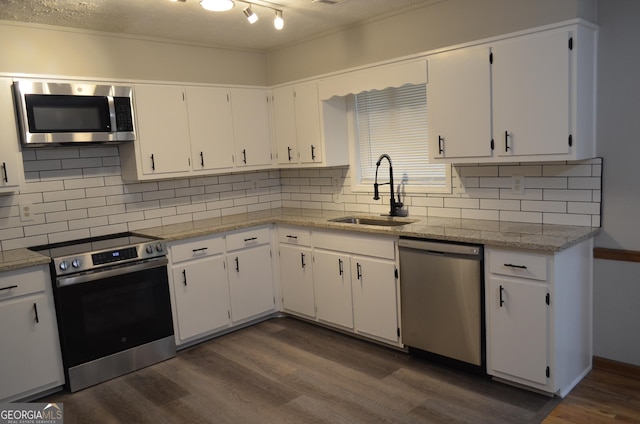 kitchen with appliances with stainless steel finishes, white cabinets, and a sink