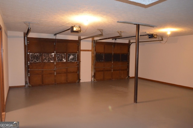 garage with a garage door opener and baseboards