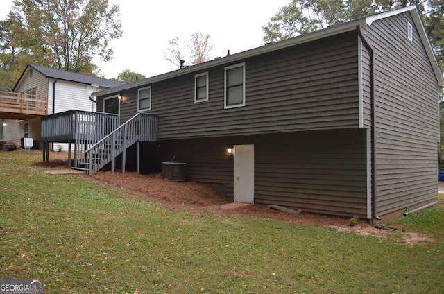 rear view of house with stairway, a lawn, and a wooden deck