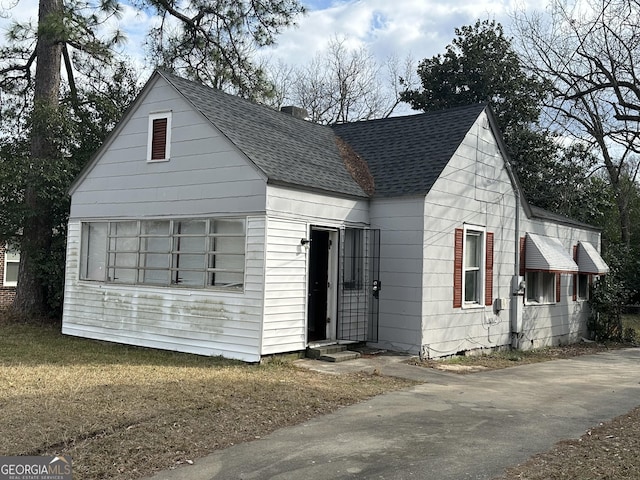 bungalow-style house with entry steps and roof with shingles