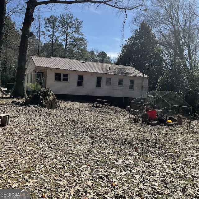 back of house featuring metal roof