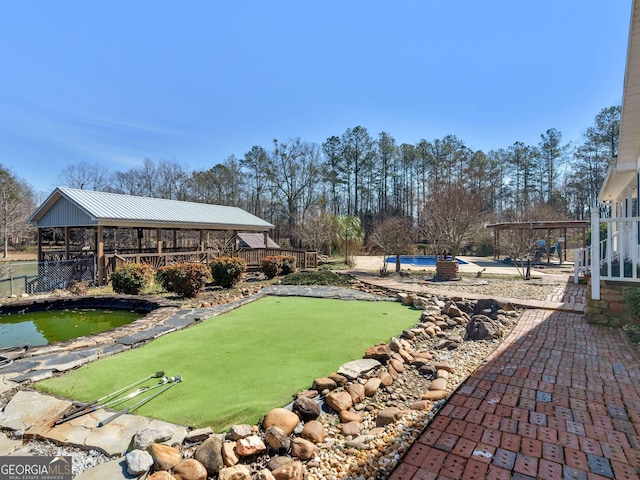 view of yard with fence and a garden pond