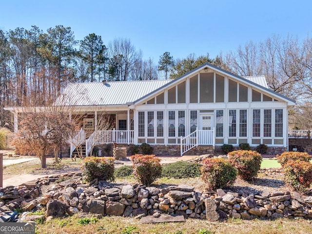 back of house featuring a sunroom and metal roof